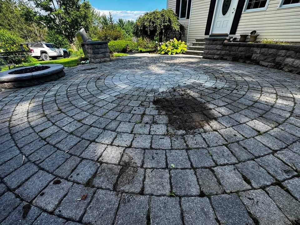Circular paver patio with dirt and organic buildup before cleaning