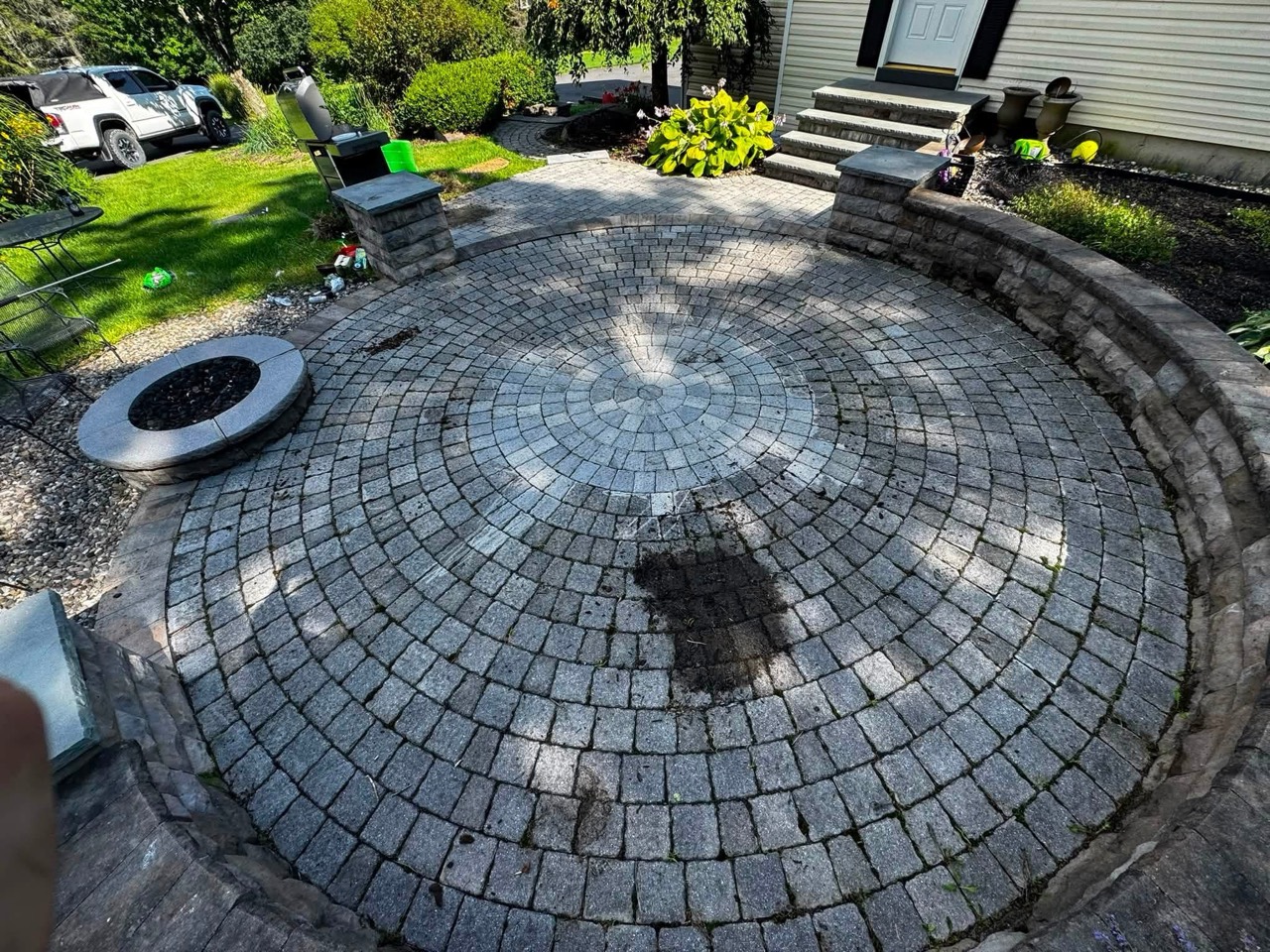 Circular paver patio viewed from above before cleaning